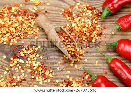 Hot Chili Peppers, Milled  Peppers Flakes and Corns In The Wood Spoon On Rustic Wooden Table Background.  Ingredients for Soup, Salad, Paste