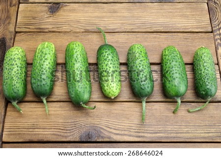 Fresh Seven Cucumbers In A Row On The Rough Rustic Wood Tabletop
