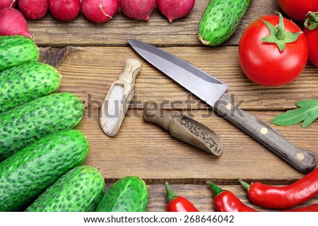 Fresh Vegetables And Knife On The Kitchen Rustic Rough Wooden Tabletop. Tomatoes, Cucumbers, Radish, Chili Peppers, Two Small Spoon With Pepper And Salt