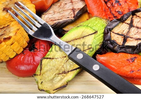 Fork and Grilled Vegetables Assortment On The Wood Cutting Board. Barbecue Food. Tomato, Bell Pepper, Zucchini, Eggplant, Sweet Corn Rings
