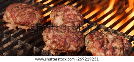 BBQ Beef Burgers on Hot Charcoal Grill. Dancing Flames On The Background