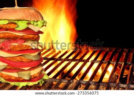 BBQ Homemade Big Cheeseburger On The Hot Charcoal Grill. Flames of Fire In the Background