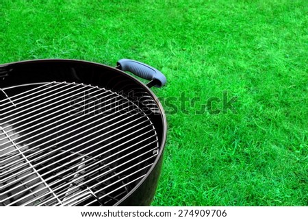 Empty Clean BBQ Charcoal Kettle Grill Close-up On The Spring Grass Background