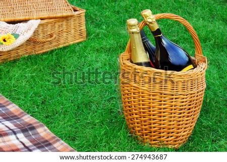 Wicker Basket With Champagne Wine,  Hamper And Blanket On Spring Emerald Color Lawn,Summer Picnic Scene Concept