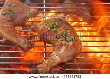 Barbecue Roast And Smoked Chicken Quarters On The Hot Flaming Charcoal Grill Background. Good Food For Outdoor Summer Barbecue Party Or Picnic