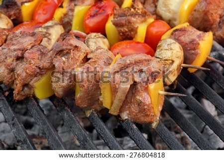 Barbecue Roasted Meat Shish Kebabs With Peppers, Tomatoes and Mushrooms On The Hot Grill. Good Snack For Outdoor Summer Barbecue Party Or Picnic