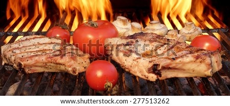 Pork Rib Steaks, Tomato And Mushrooms On Hot Flaming BBQ Charcoal Grill