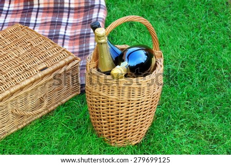 Basket With Champagne Wine,  Hamper And Blanket On The Lawn, Summer Picnic Scene Concept