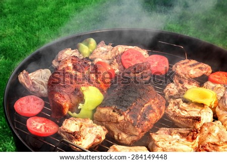 Mixed Meat And Vegetables On The Hot BBQ Charcoal Grill. Pork Ribs, Knuckle, Chicken Cuts, Paprika, Tomato