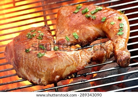 Close-up Of Two BBQ Marinated Chicken Legs On The Hot Flaming Charcoal Grill Background