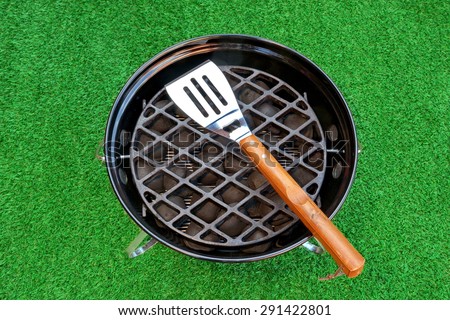Close-up Overhead View Of BBQ Grill With Tools On The Fresh Lawn. Holiday Barbecue Grill Party Or Weekend Picnic Concept.