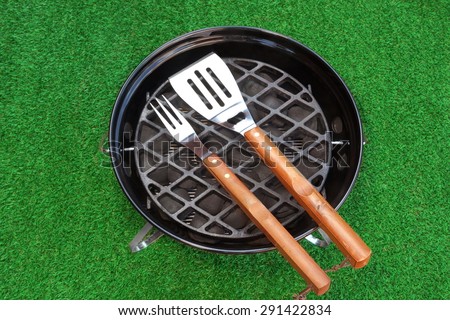 Close-up Overhead View Of BBQ Grill With Tools On The Fresh Lawn. Holiday Barbecue Grill Party Or Weekend Picnic Concept.
