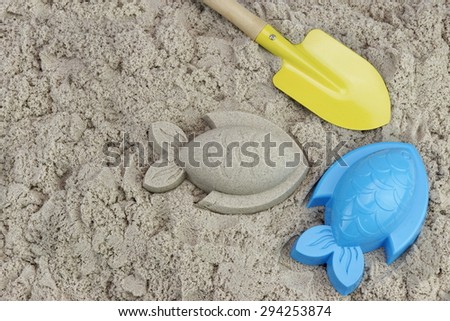 Sand Fish, Yellow Small Shovel And Plastic Mold On The Sea Beach Close-up High Angle View