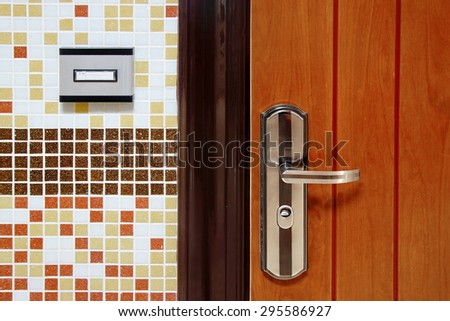 Doorbell Ring Button On The Wall And Metal Door With Handle Close-up