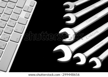 Wrenches With Sign Chrome And  Wireless Keyboard Isolated On Black  Background. Remote Assistance Or Technical Support Or Repair Service Or Bug Fix  Or Business Solutions Concept