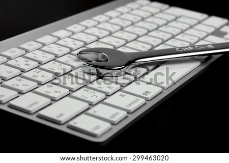 Single Chrome Plated Wrench And  Wireless Keyboard Isolated On Black  Background. Remote Assistance Or Technical Support Or Repair Service Business  Concept