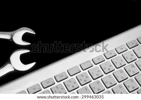 Two Chrome Plated Wrenchese And  Wireless Keyboard Isolated On Black  Background. Remote Assistance Or Technical Support Or Repair Service Business  Concept