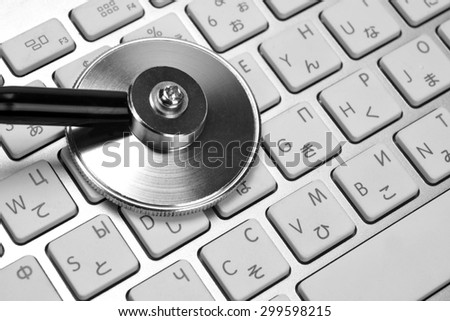 Close-up Of Stethoscope And Multilingual  Wireless Keyboard Background. Technical Support Or Repair Service Or Data Storage Or Information Security Concept