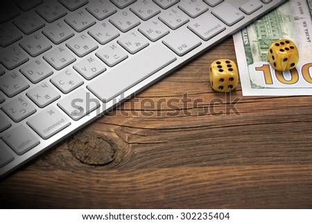 Computer Keyboard, Gaming Dices And USA Dollar Cash On The Rough Brown Wood Background. On Line Gambling Game Concept