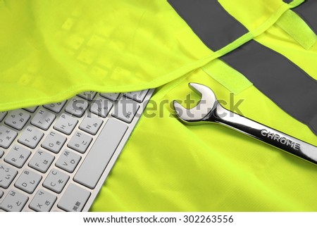 Keyboard In The Yellow Safety Reflective Vest And Wrench. Technical Or Road Assistance Concept With Copy Space