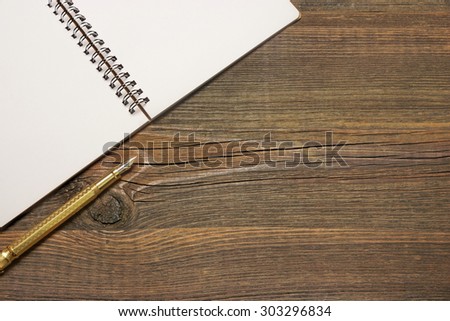 An Open Spiral Bound Notebook With White Pages And Gold Fountain Pen On The Rough Rustic Wood Table. Overhead View