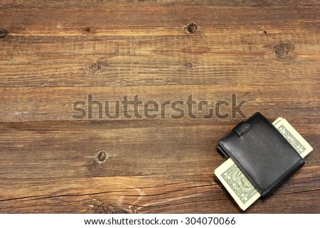 High Angle View Of Modern Black leather Men\'s Wallet With Dollar Cash On The Old Rough Wood Textured Background With Copy Space