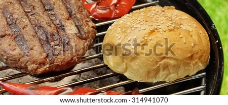 Barbecue Burgers On The Hot Charcoal Grill. Cookout Concept. Good Snack For Summer Outdoor Party Or Picnic.Backyard Lawn In The Background.