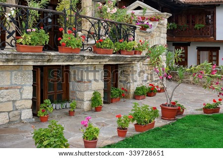 Natural Stone Landscaping In The Backyard And Many Flowers In The Pot