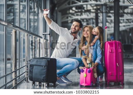 Family in airport. Attractive young woman, handsome man and their cute little daughter are ready for traveling! Happy family concept.