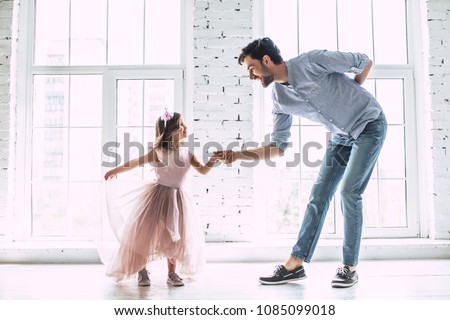 I love you, dad! Handsome young man is dancing at home with his little cute girl. Happy Father\'s Day!