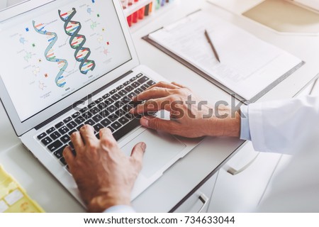 Cropped image of senior experienced scientist is working in laboratory. Doing investigations using laptop