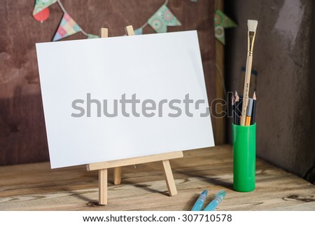 Art supplies. Brushes, easel, paper. Place for your text. Mock up photography.