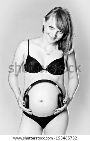 Pregnant woman plays music to her unborn child (black and white)