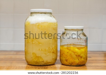 Lemons covered with sugar in jar, lemon peels in jar, preparation for lemon liquor