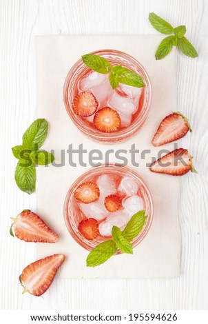 lemonade with strawberries and fresh mint and liqueur on white background
