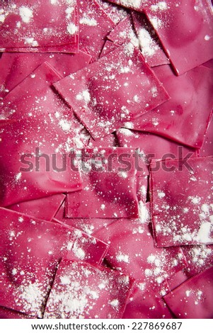 Close up homemade fresh Italian red ravioli with beetroot & cheese with spinach