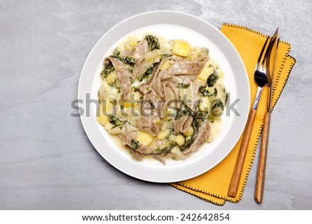pasta pizzoccheri with chinese cabbage, potato on grey. italian traditional dish