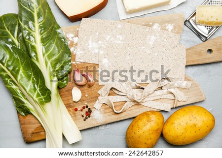 pasta pizzoccheri raw, chinese cabbage, potato on grey
