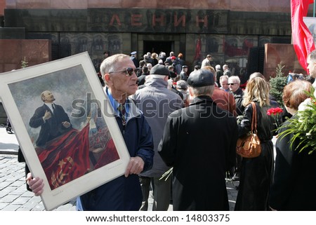 MOSCOW - APRIL 22: Man holds a picture of the Soviet founder Vladimir Lenin marking the 138th anniversary of Lenin\'s birth, in front of the Mausoleum at Red Square April 22, 2008 in Moscow, Russia.