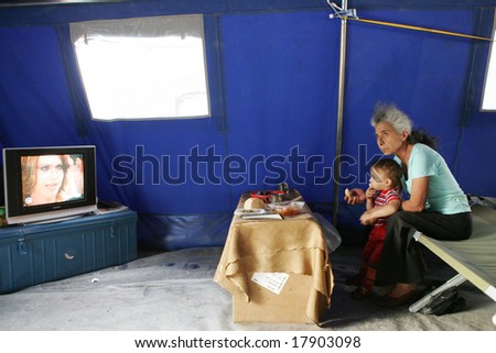 GORI, GEORGIA - SEPTEMBER 8: An old woman and her granddaughter watch TV in a tent  at a refugee camp on September 8, 2008 in Gori, Georgia.