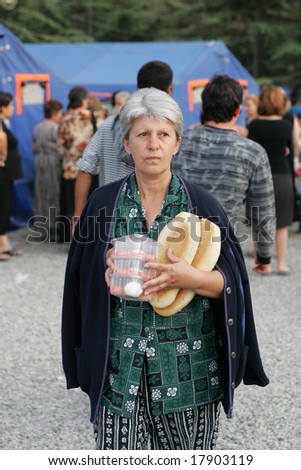 GORI, GEORGIA - SEPTEMBER 8: A woman carries food distributed by the Red Cross at a refugee camp on September 8, 2008 in Gori, Georgia.