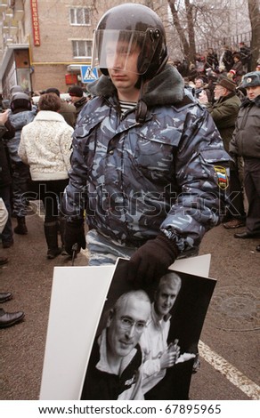 MOSCOW - DECEMBER 27: Russian police officer confiscates posters in support of Mikhail Khodorkovsky after some people have been detained at a rally outside the court December 27, 2010 in Moscow, Russia.