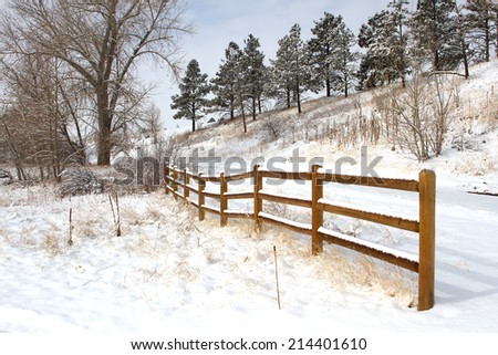 Split rail fence along a snowy path
