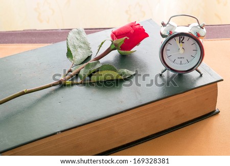 rose and old diary with clock.