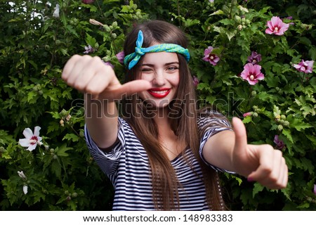 trendy teenager model with big lips showing thumbs up and wink