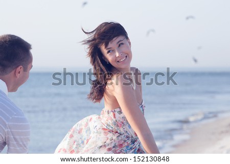 Beautiful Girl running from her boyfriend during summer time fun on the seashore
