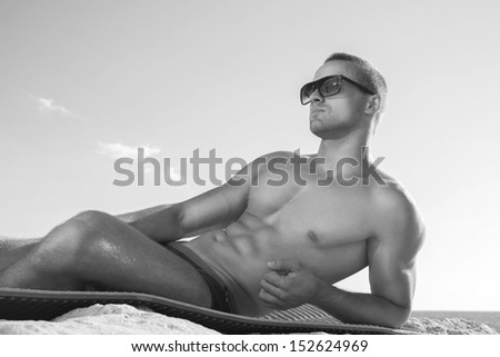 Trendy perfct body guy posing on the beach. Black and white
