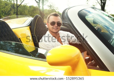 Back view of young driver in sunglasses of convertible ride