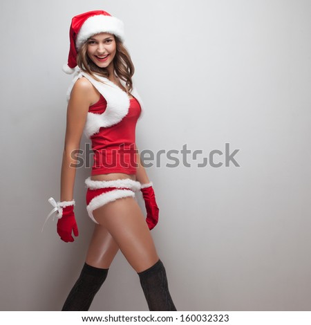Walking girl in christmas costume. Short red shorts, fur Vest, hose, red mittens