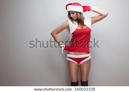 Dancing girl in christmas costume. Short red shorts, fur Vest, hose, red mittens